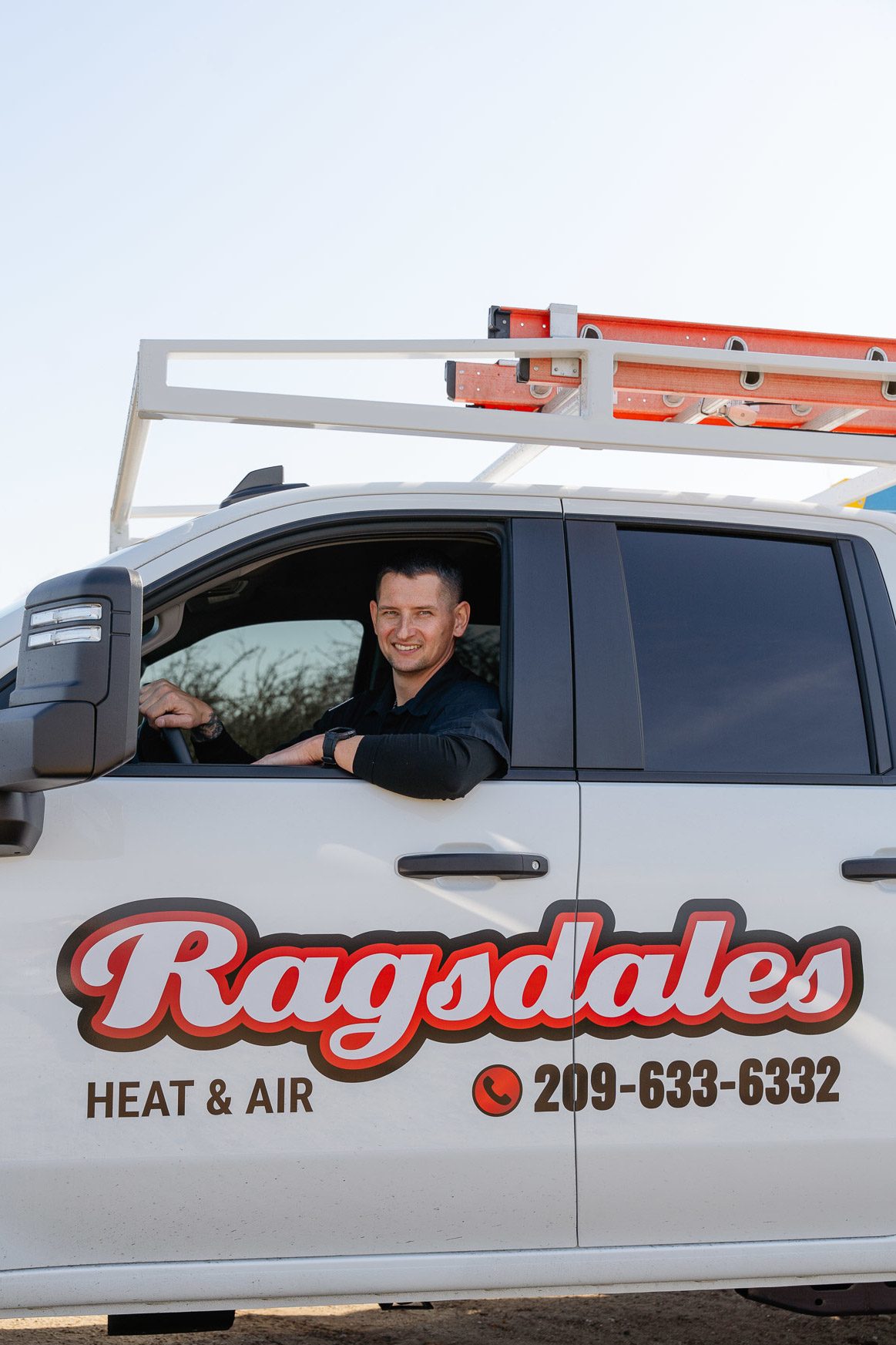 A Ragsdales Heating, Air Conditioning technician next to a company vehicle